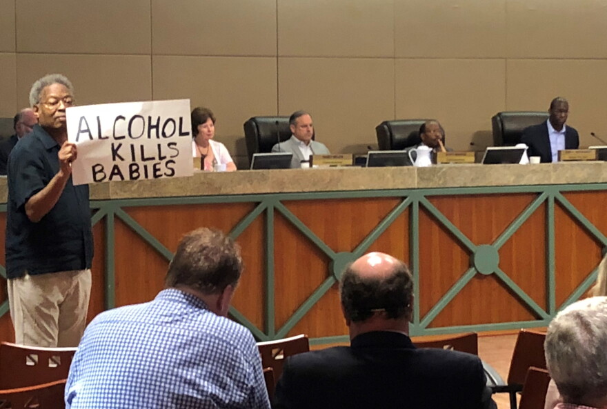 Man holds up a sign during the Monday CRA meeting