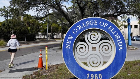 A student makes her way past the sign at New College of Florida, Jan. 20, 2023, in Sarasota, Fla. Attorneys for New College of Florida, the traditionally progressive public liberal arts college which was taken over by allies of Gov. Ron DeSantis as part of his “war on woke,” last week threatened to sue a group of former faculty members and students. It's because they have formed an alternative online institute named “Alt New College” after departing the school following the takeover.