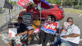 Supporters of candidates hold signs outside of polling locations.