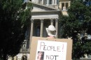 woman at Capitol with "People Not Politics" sign