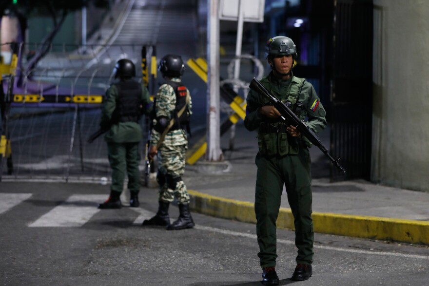 Soldiers guard the area around the Miraflores presidential palace after explosions and low-flying aircraft were heard in Caracas, Venezuela, Saturday, Jan. 3, 2026. (AP Photo/Cristian Hernandez)