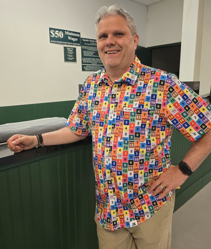 Greg Bush, executive Director for Special Projects at the Downs, stands at a teller booth in a multicolored shirt.jpg