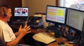 Rural commodities broker Tom Leffler checks the markets and speaks to a client on the phone.