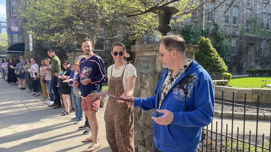 Patrons of Prologue Bookshop in the Short North pass about 200 books down a human chain from the shop's old location to a new, larger space down the street on April 9, 2026.