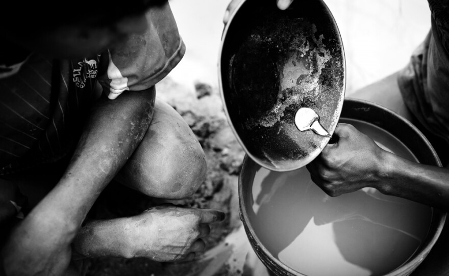 After 12 hours of dredging and another hour separating the gold particles from the sediment, a young miner pours the gold amalgam — a mix of liquid mercury and gold particles — into a container, which will then be taken to a gold shop where the mercury is burned off, leaving raw gold.