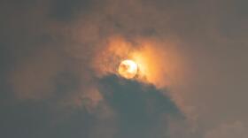 The sun peeks through the clouds and yellow haze of wildfire smoke over the Boston area on Wednesday morning. (Jesse Costa/WBUR)