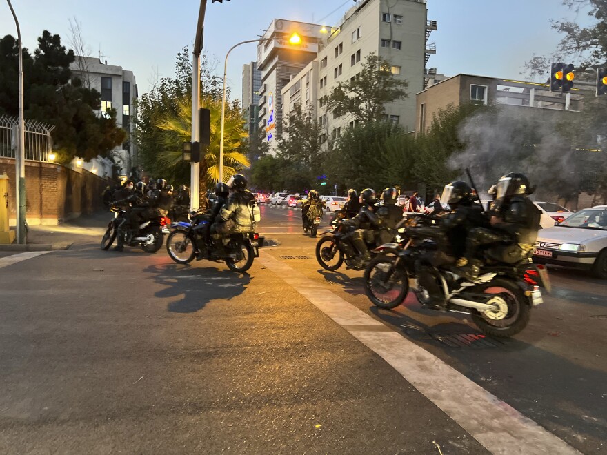 In this photo taken by an individual not employed by the Associated Press and obtained by the AP outside Iran, anti-riot police arrive to disperse demonstrators during a protest over the death of a young woman.