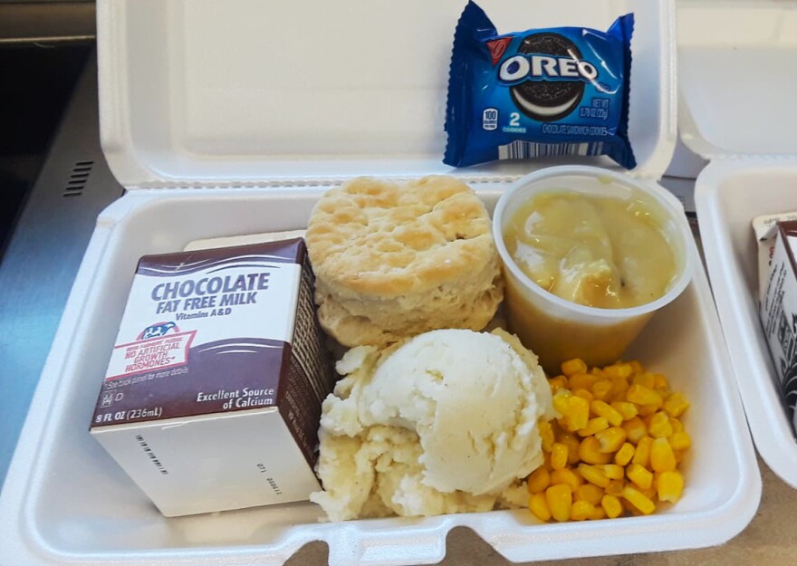 A school meal of turkey, mashed potatoes, corn, oreos and chocolate milk.