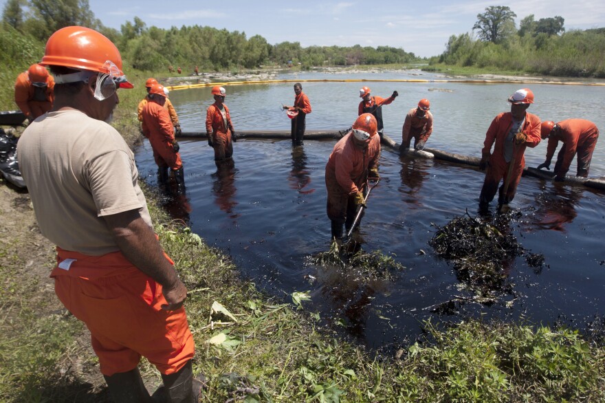 Workers from Pemex clean the San Juan river after an oil spill caused by fuel pirates who tapped into a pipeline in Nuevo Leon state, Mexico, in August 2014. Fuel pirates are one of many above-ground complications in opening up the oil fields of northern Mexico.