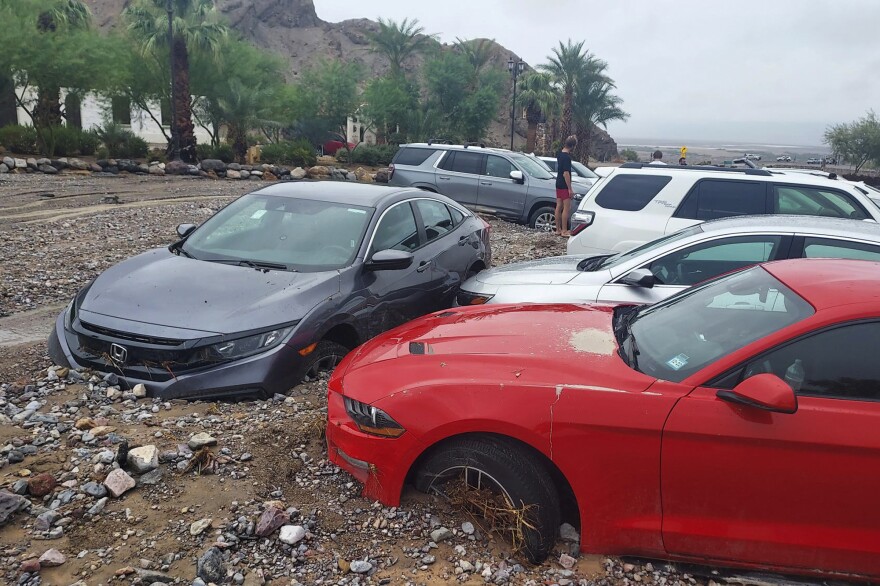 In this photo provided by the National Park Service, cars are stuck in mud and debris from flash flooding at The Inn at Death Valley in Death Valley National Park on Aug. 5, 2022.