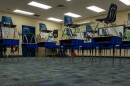 Blue chairs stacked on top of desks in a classroom