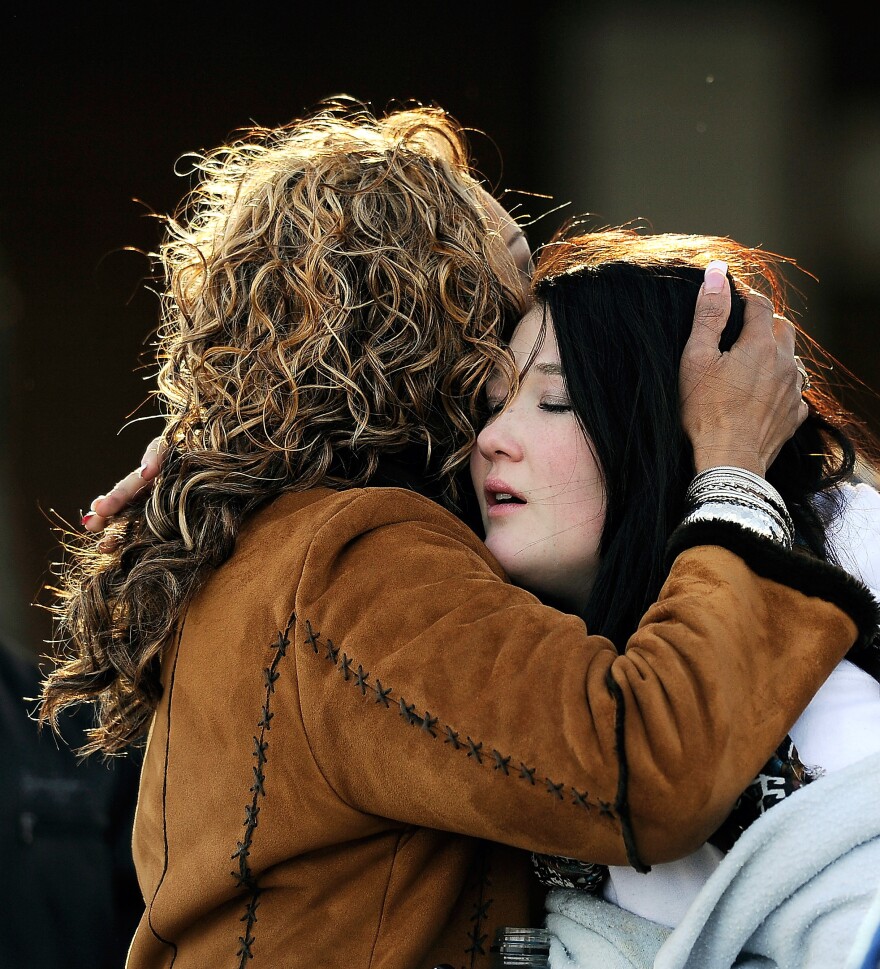 A woman hugs a student at Shepherd of the Hills Church near Arapahoe High School after a school shooting on Friday in Centennial, Colorado.