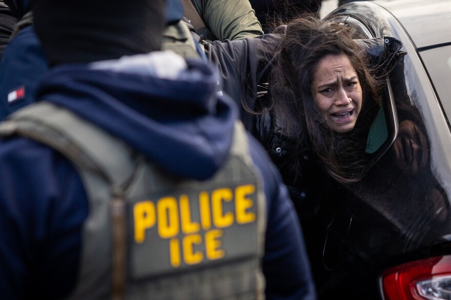 Federal ICE agents pull a woman from her car during an enforcement operation in south Minneapolis on Tuesday, Jan. 13, 2026 — part of a broader federal immigration crackdown that has drawn protests and scrutiny after multiple confrontations between ICE and residents of the city.