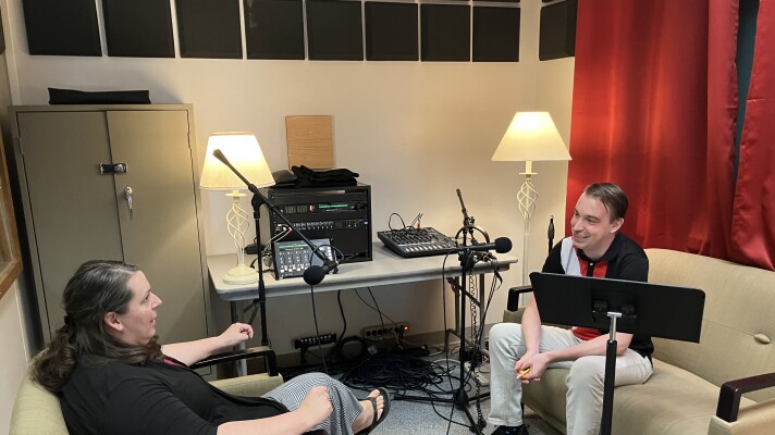 Two people sitting in an interview room. 