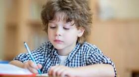 Little boy writing at his desk