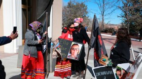 FILE - Seraphine Warren, center left, is embraced by state New Mexico state Sen. Shannon Pinto while holding a poster with Warren's aunt Ella Mae Begay's photo on it outside the state capitol building Feb. 4, 2022, in Santa Fe, N.M. (AP Photo/Cedar Attanasio, File)