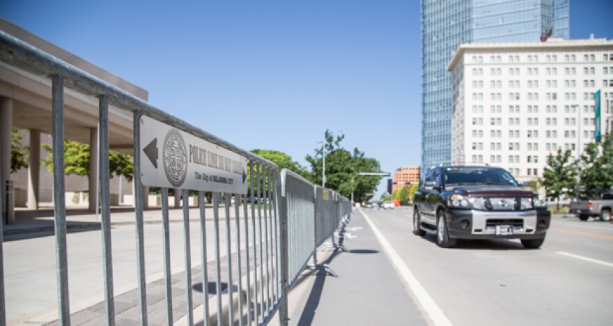 A motorist drives by a police barricade placed along Sheridan Avenue in downtown Oklahoma City in advance of a visit from President Barack Obama Wednesday.