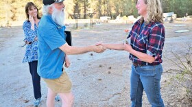 Elk Cemetery Commission challenger Steven Queener, left, shakes hands with incumbent Commissioner Rebecca Shannon Wednesday, Sept. 24, 2025, at Elk Cemetery as Queener’s campaign health care consultant, Dr. Bernadine Bank, smiles.