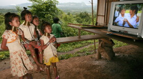 Young girls of the Long Neck Padaung hill tribe watch television in a small village in Chiang Dao, Thailand. By custom, girls in the tribe wear brass rings around their necks, beginning at age 5.