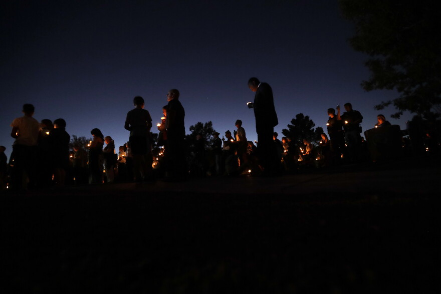 People hold candles during a vigil in honor of Las Vegas police officer Charleston Hartfield Thursday, Oct. 5, 2017, in Las Vegas. Hartfield was killed during the Sunday night mass shooting at the Route 91 Harvest country music festival. (AP Photo/Gregory Bull)