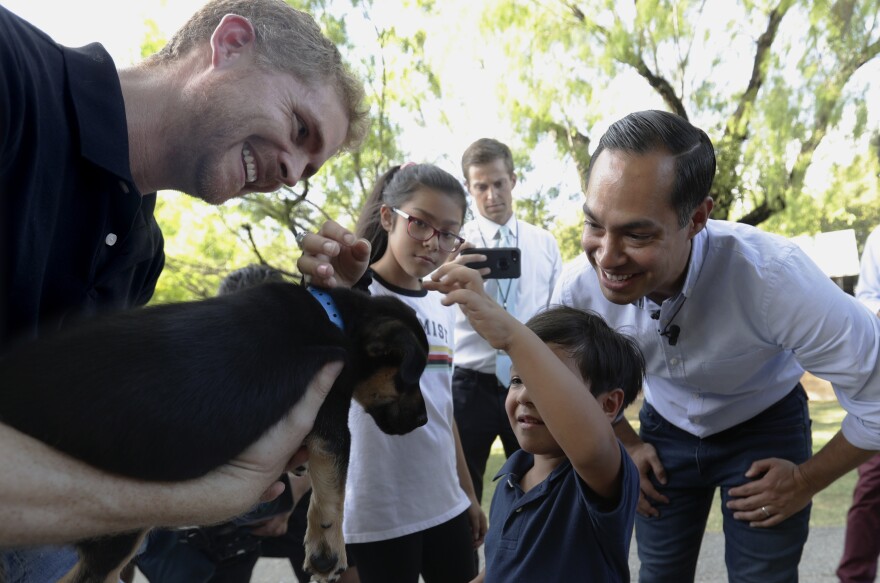 Former Housing secretary Julián Castro, right, his son Cristian and daughter Carina visit Ivan, a puppy up for adoption, during a stop at the Animal Defense League of Texas shelter in San Antonio.