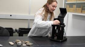 UAF Critical Minerals Lab analyst Piper Kramer places a rock sample in an x-ray spectrometer on Jan. 7, 2025.
