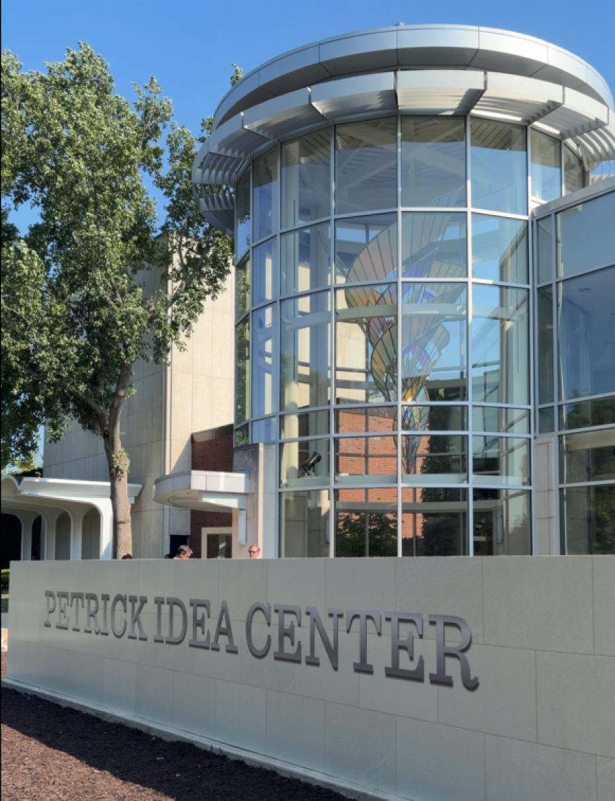 a sign in front of a glass building entrance
