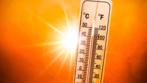 Background for a hot summer or heat wave, orange sky with with bright sun and thermometer