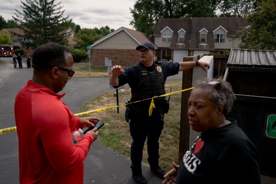 A St. Louis County police officer tells residents they can not return to their homes after a house exploded earlier in the day, destroying 4 other homes and severely damaging others on Monday, Aug. 25, 2025, near Black Jack, Mo.