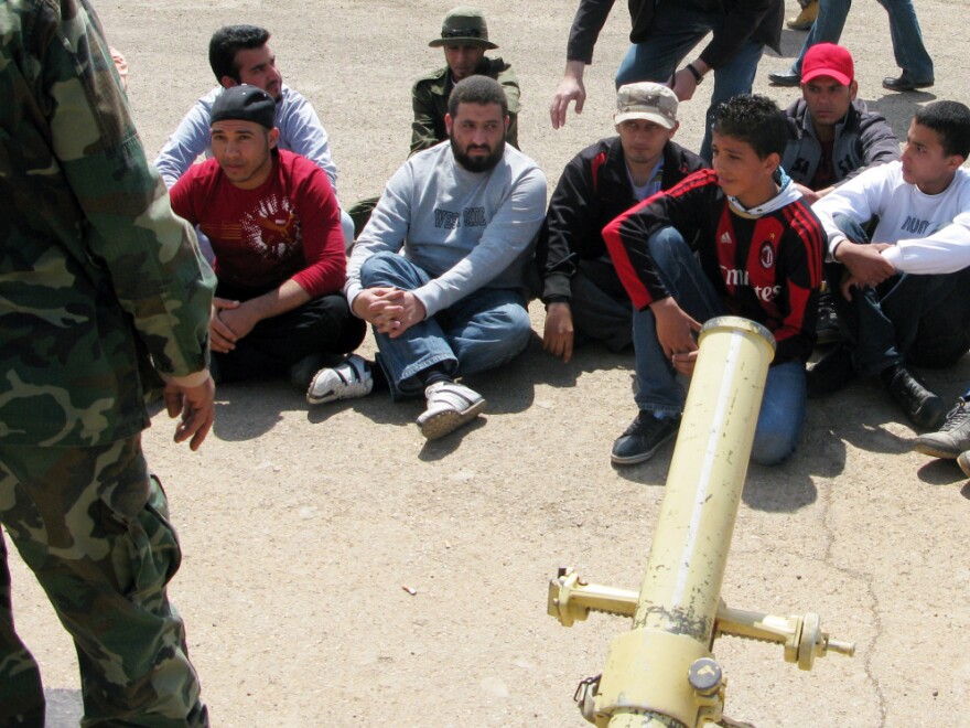 Ihab Budabuus (front, second from right) and other recruits are learning with live fire in the cement lot of a military base in Benghazi.