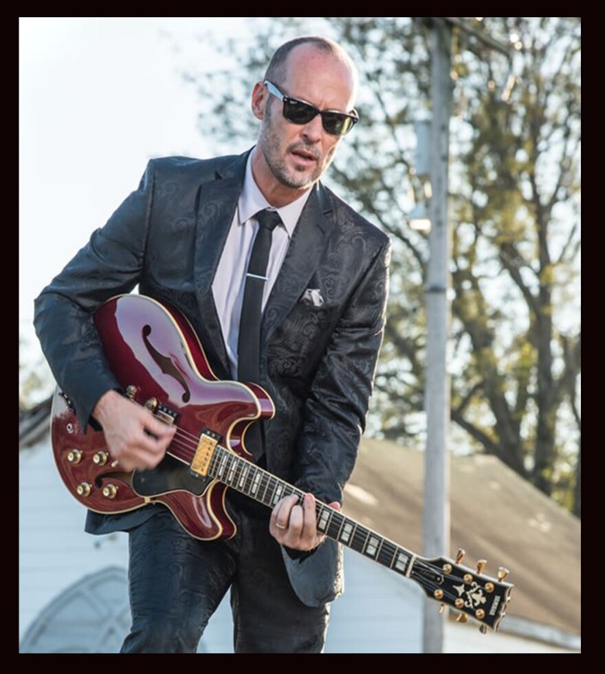 Musician playing guitar in front of a church