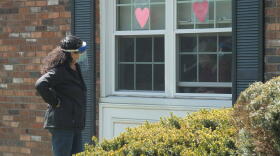 An employee at nursing facility Kimberly Hall South in Windsor visits with a resident through her window in May.