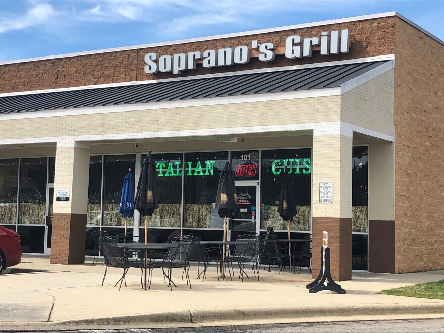 A man shot and wounded by a Raleigh Police officer on Tuesday, was seen by a 911 caller outside Soprano's Grill, allegedly flashing a gun.
