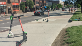 Electric scooters scattered on the sidewalk at Ohio State University.