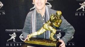 Perpetual sports fan, Steve Tannen with the Heisman Trophy