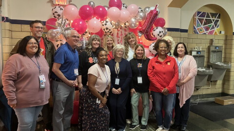 Longfellow School staff, Rock Island-Milan School District leaders and Board of Education members pose for a photo during "Dolly Day" Friday morning, Sept. 25 at the Rock Island elementary school.