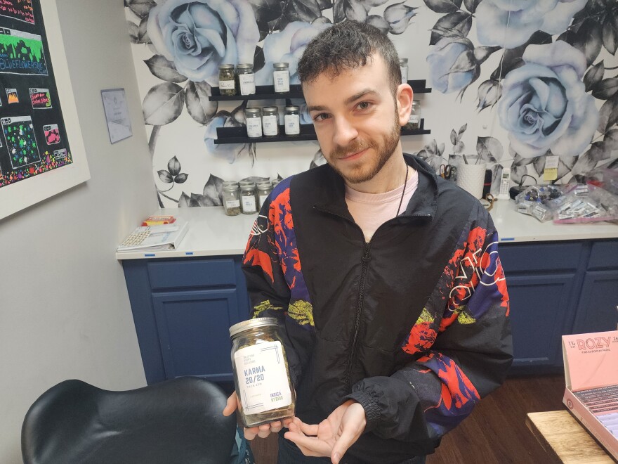 Nick Davenport, who works at Blue Flowers in SouthPark, displays a jar of hemp flower.