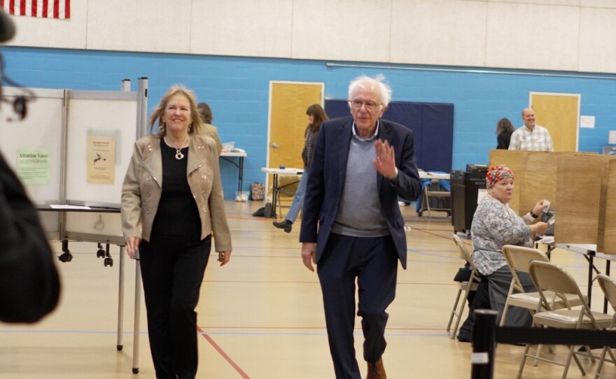 woman and man walk through a gymnasium and wave
