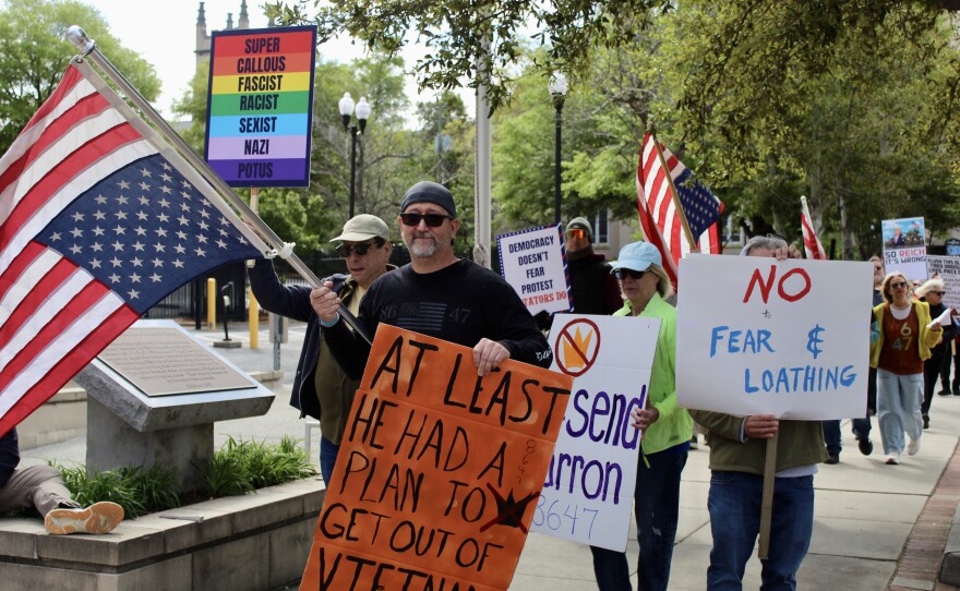 Protestors holding signs and marching towards Innes Park in downtown Wilmington.