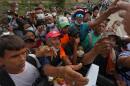 People reach out to receive supplies from volunteers, days after an earthquake struck La Guaira, Venezuela, Tuesday, June 30, 2026.