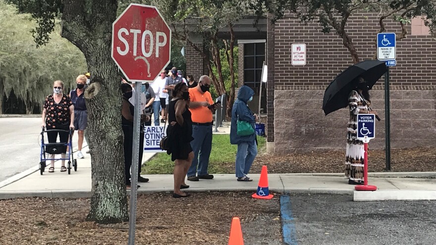 Early voters wait in line Monday at the Regency Branch of the Jacksonville Public Library.