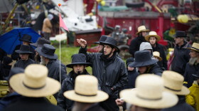 An auctioneer takes bids for farm equipment during the 56th annual mud sale to benefit the local fire department in Gordonville, Pa., Saturday, March 9, 2024. Mud sales are a relatively new tradition in the heart of Pennsylvania's Amish country, going back about 60 years and held in early spring as the ground begins to thaw but it's too early for much farm work. 