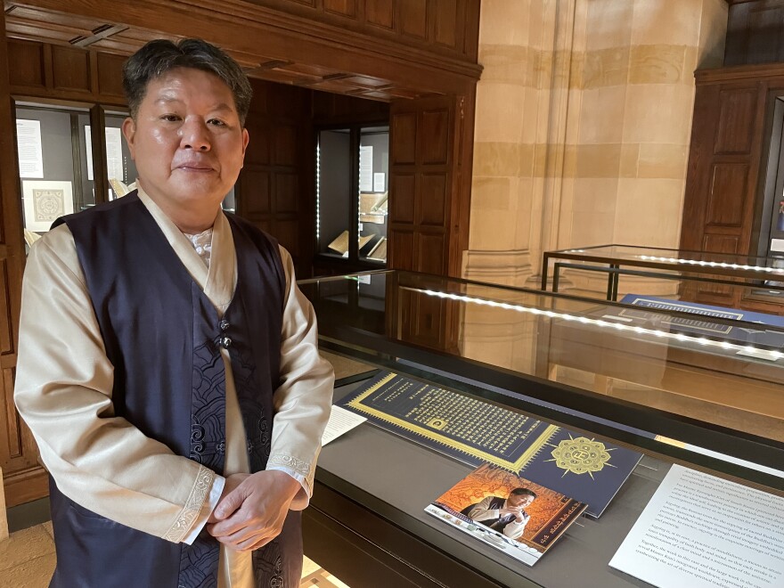 Kim Kyeong-Ho with his work in Sterling Memorial Library's Hanke Gallery.