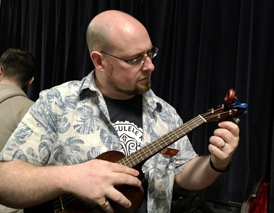 Mike Holzer, president of the Allegheny Ukulele Kollective, tunes an instrument before a class 