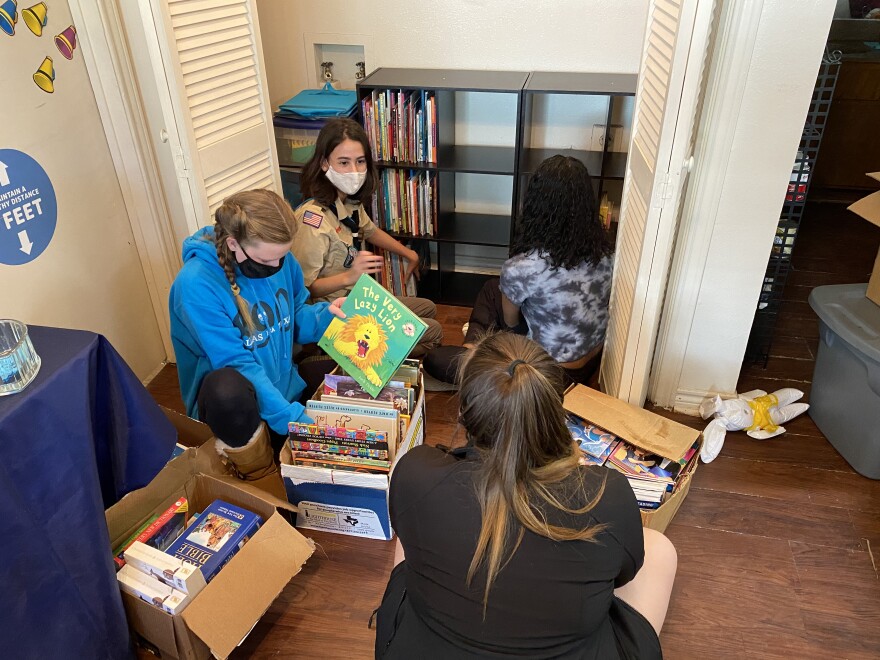 Others scouts from Troop 890 help Madison Knefley sort through books and organize them on the shelves. She put together the community library for her eagle project — one of the last requirements she needed to finish to receive her Eagle Scout rank and pin at a ceremony in February. 