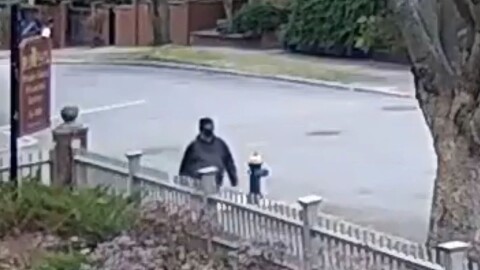 A person of interest in the Brown University shooting walks on a Providence street, as seen in security footage released by the Providence Police.