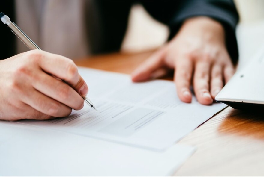 Hand holding pencil filling out a ballot