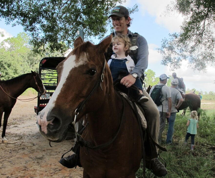 Carlton Ward Jr. cradles his son, Carlton III, before taking off on horseback from Highlands Hammock State Park