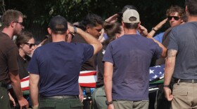 The body of a firefighter who died battling wildfires near the Colorado-Utah border is carried during a procession in Grand Junction, Colo., Monday, June 29, 2026. (AP Photo/Ty ONeil)