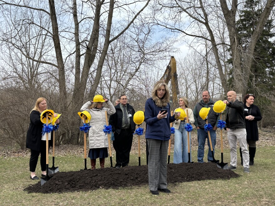 A woman stands in front of Stoneleigh Residence employees before they break ground on the new expansion. 